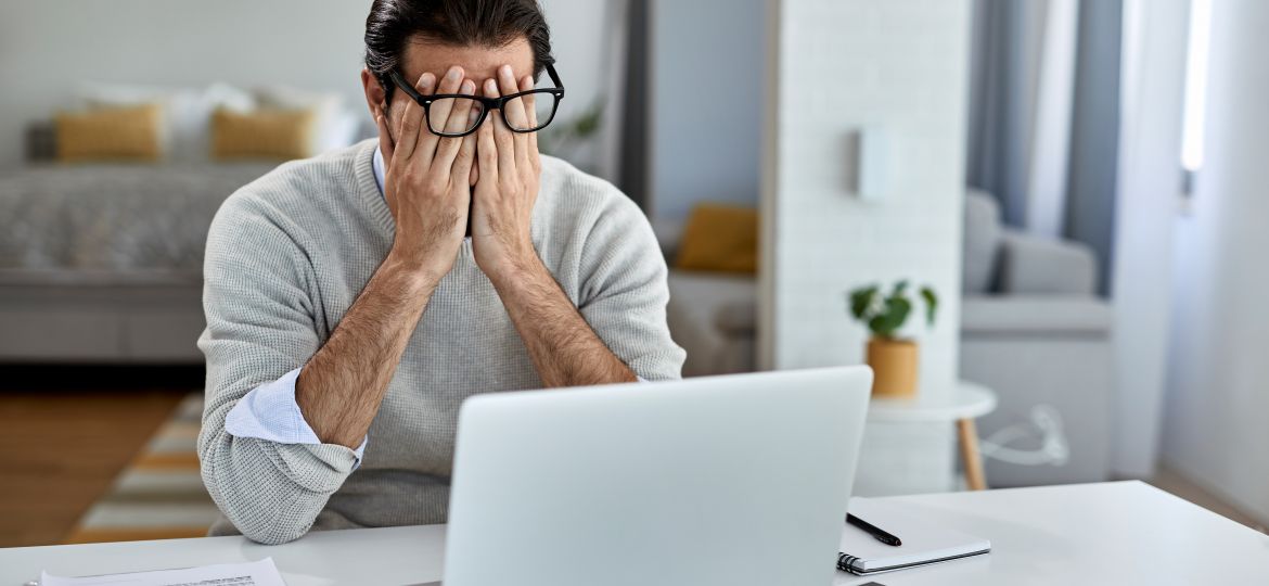 Tired male entrepreneur working on a computer at home.